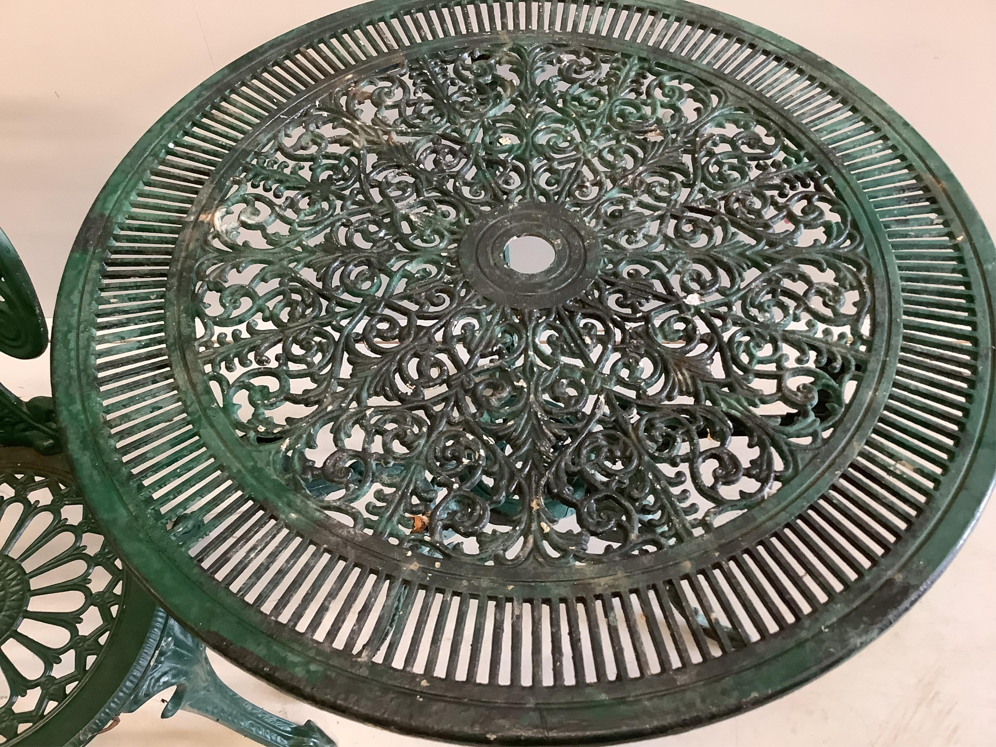 A Victorian style circular painted aluminium garden table, diameter 80cm, height 68cm, together with two chairs. Condition - fair
